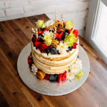 Naked cake with fruit flowers and cookie decoration