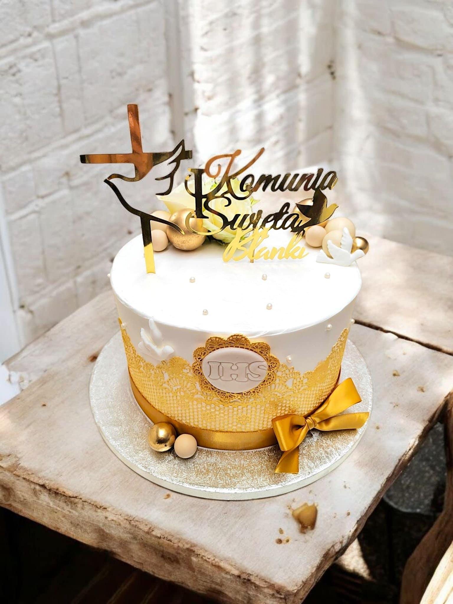 Elegant holy communion cake with fresh flowers and lace